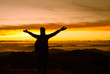 © kieferpix - silhouette of female standing on top a mountain with open arms