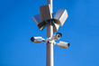 CCTV Security Camera And Loudspeaker Or Speaker With Clear Blue Sky On Background. Security And Protection Of Public Order And Peace.