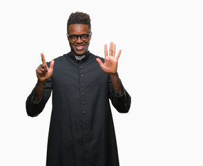 Sticker - Young african american priest man over isolated background showing and pointing up with fingers number seven while smiling confident and happy.