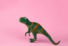 Funny Green Dinosaur Toy On Pastel Pink Background