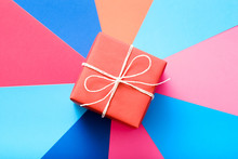 Red Gift Box On Colorful Background. Present As A Reward And Gratitude On Special Occasion.