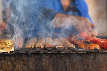Wall Mural - Traditional Adana kebab on the barbecue with smoke, close up
