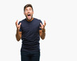 Young handsome man over isolated background crazy and mad shouting and yelling with aggressive expression and arms raised. Frustration concept.
