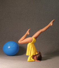 a girl in a yellow dress in the gym is engaged in gymnastics