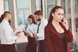 © salomonus_ - Girl talking on mobile phone. Young team of office workers. Girl in glasses. Business lady