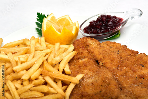 Cuadros en Lienzo Italian food, Milanese schnitzel with fries served on white plate, isolated on