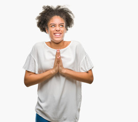 Sticker - Young afro american woman over isolated background begging and praying with hands together with hope expression on face very emotional and worried. Asking for forgiveness. Religion concept.