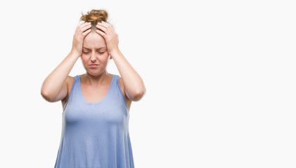 Wall Mural - Young blonde woman suffering from headache desperate and stressed because pain and migraine. Hands on head.