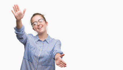 Wall Mural - Young blonde business woman looking at the camera smiling with open arms for hug. Cheerful expression embracing happiness.