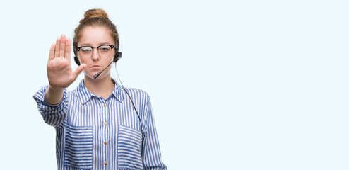 Canvas Print - Young blonde call center operator woman with open hand doing stop sign with serious and confident expression, defense gesture