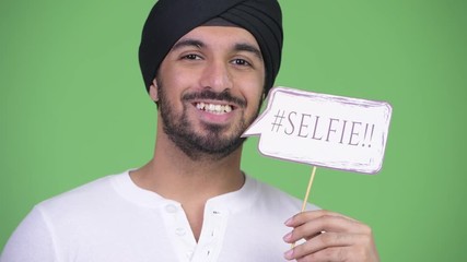 Canvas Print - Young happy bearded Indian man with selfie paper sign