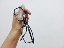 Hand Holding Glasses On White Wall Background