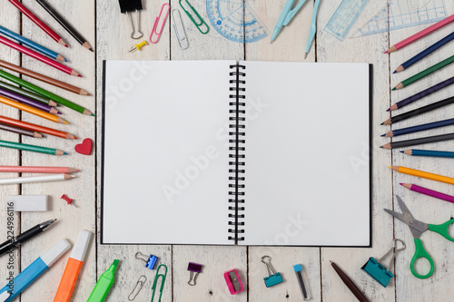 Foto Empty notebook and colorful pencils on white wooden table
