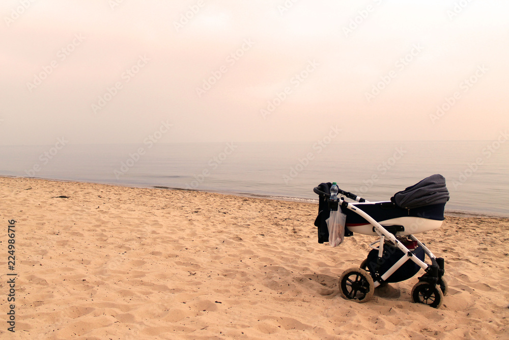 dziecięcy wózek stojący na plaży - obrazy, fototapety, plakaty 