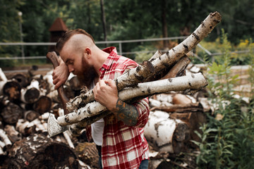 Wall Mural - Bearded mohawk Man with firewoods and with axe on shoulder