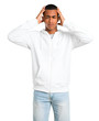 © luismolinero - Dark-skinned young man with white sweatshirt unhappy and frustrated with something. Negative facial expression on isolated white background
