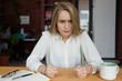 © Anatoliy Karlyuk - People, lifestyle and negative human emotions. Furious young businesswoman in white blouse working while sitting at cafeteria during coffee break, being angry because her lunch is not ready yet
