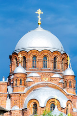 Beautiful Orthodox church with a gilded cross against the blue cloudy sky