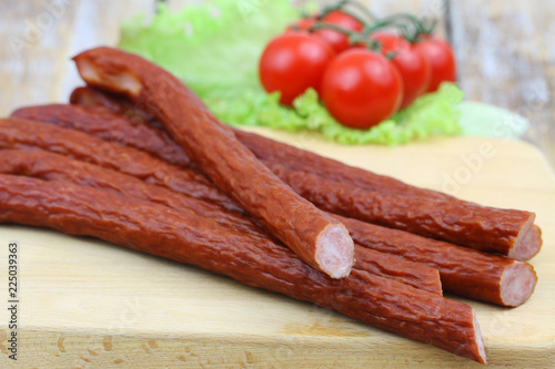 Fotografie, Obraz Traditional Polish smoked kabanos on wooden board, closeup