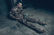 © VadimGuzhva - Soldier Is Sitting In War Shelter With Shotgun.