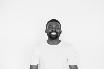 Single handsome muscular Black man with beard, folded arms and cheerful expression. black and white portrait