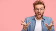 © WHstudio Leushin N - Annoyed young Caucasian guy gestures with hands angrily, opens mouth and frowns face in discontent, poses against pink background with copy space for your advertisement or promotion, asks what to do