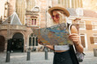 Traveler girl hold and look map in Amsterdam. Hipster tourist searching right direction on map, lifestyle concept adventure
