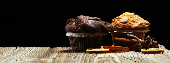 Chocolate muffin and nut muffin, homemade bakery on wooden background.