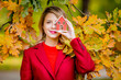 © Masson - Young woman in red coat with house toy in autumn season park.