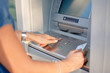© Big blue - Close-up Of Person Using Credit Card To Withdrawing Money From ATM Machine
