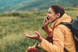 © Yakobchuk Olena - Cheerful delighted young woman sitting in the mountain hills while having a conversation on phone