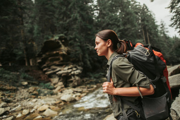 Wall Mural - Nice young woamn wearing a backpack while traveling in the mountains