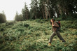 I lost my way. Full length portrait of brave girl with backpack searching the road while walking through coniferous wood