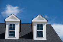 Typical American House  With Dormer Window With A Gable Roof Blue Cloudy Sky Background On A New Construction In Maryland