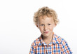 © ShannonK - Adorable, curly haired little boy trying not to laugh, isolated on white background