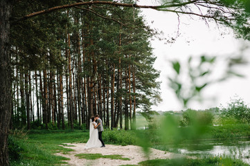 Wall Mural - Happy bride and groom getting married in the green forest. Wedding ceremony.