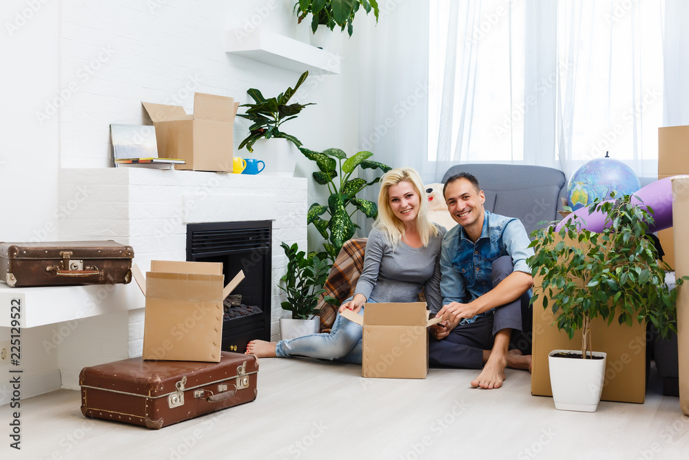 Young couple on the floor after moving into a new home with boxes ...