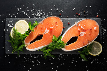 Wall Mural - Salmon. Raw Trout Red Fish Steak served with Herbs and Lemon and olive oil on slate.