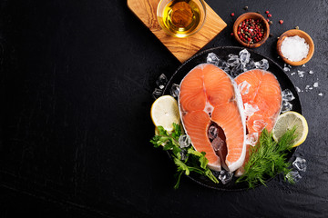 Wall Mural - Salmon. Raw Trout Red Fish Steak served with Herbs and Lemon and olive oil on slate.