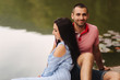 © Aleksandr - A guy and a girl enjoy each other in a romantic atmosphere, sits on the pier