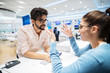 © Dusan Petkovic - Young female costumer in electronic store talking to salesman.