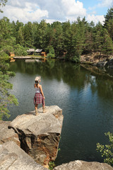 Poster - Young woman on rocky mountain near lake. Camping season