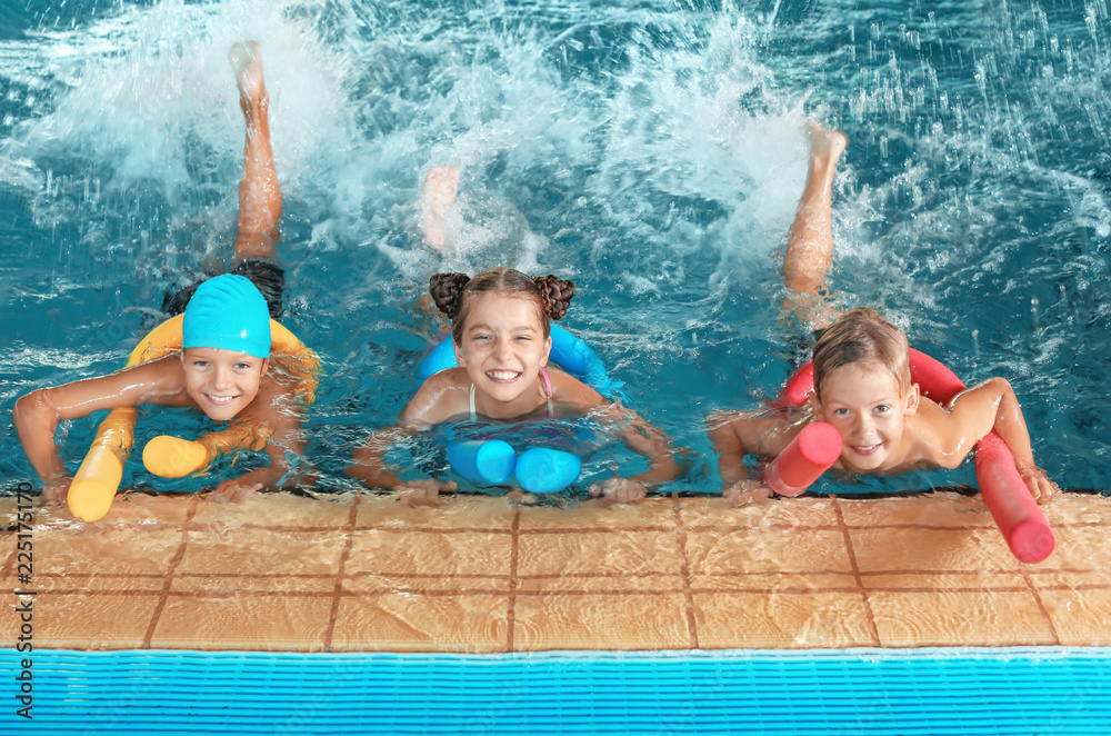 Little kids with swimming noodles in indoor pool - obrazy, fototapety, plakaty 