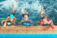 Little Kids With Swimming Noodles In Indoor Pool