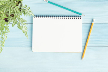 Wall Mural - blank notebook with and pencil on blue background,flat lay photo of notebook for your message