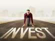 © ra2 studio - Young determined businessman kneeling before invest sign