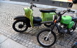 Grüner Motorroller und grünes Moped auf grauem Kopfsteinpflaster