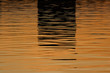 Beautiful reflections on the water before sunset in orange and dark colors  – background image, Moscow river, Russia