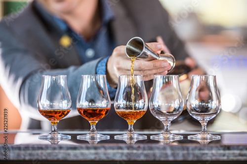 Fotomural Bartender professional preparing five alcololic drinks.