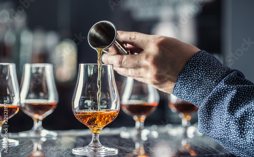 Fotografía Bartender hand pouring alcoholic drink in nightclub, bar or pub.